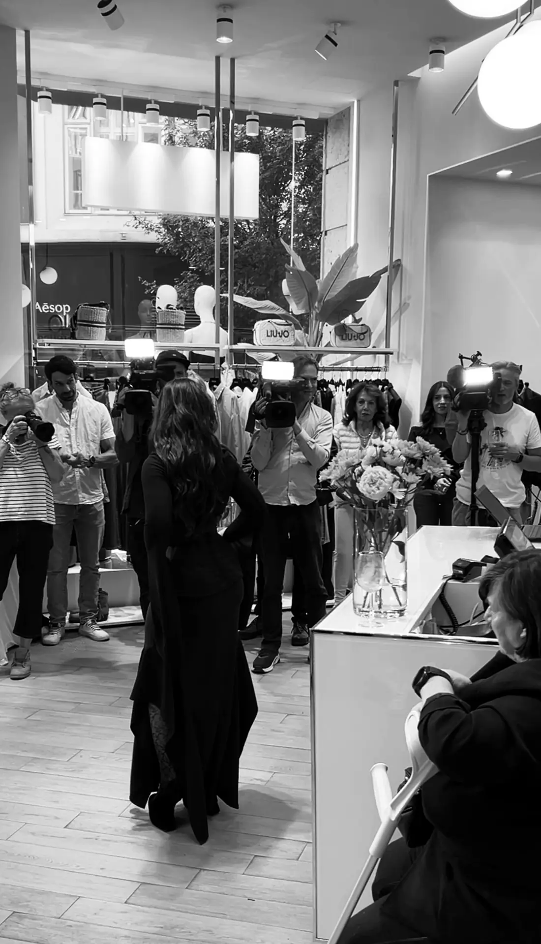 At the charity event: the outfit on the shop floor among guests and cameras.
